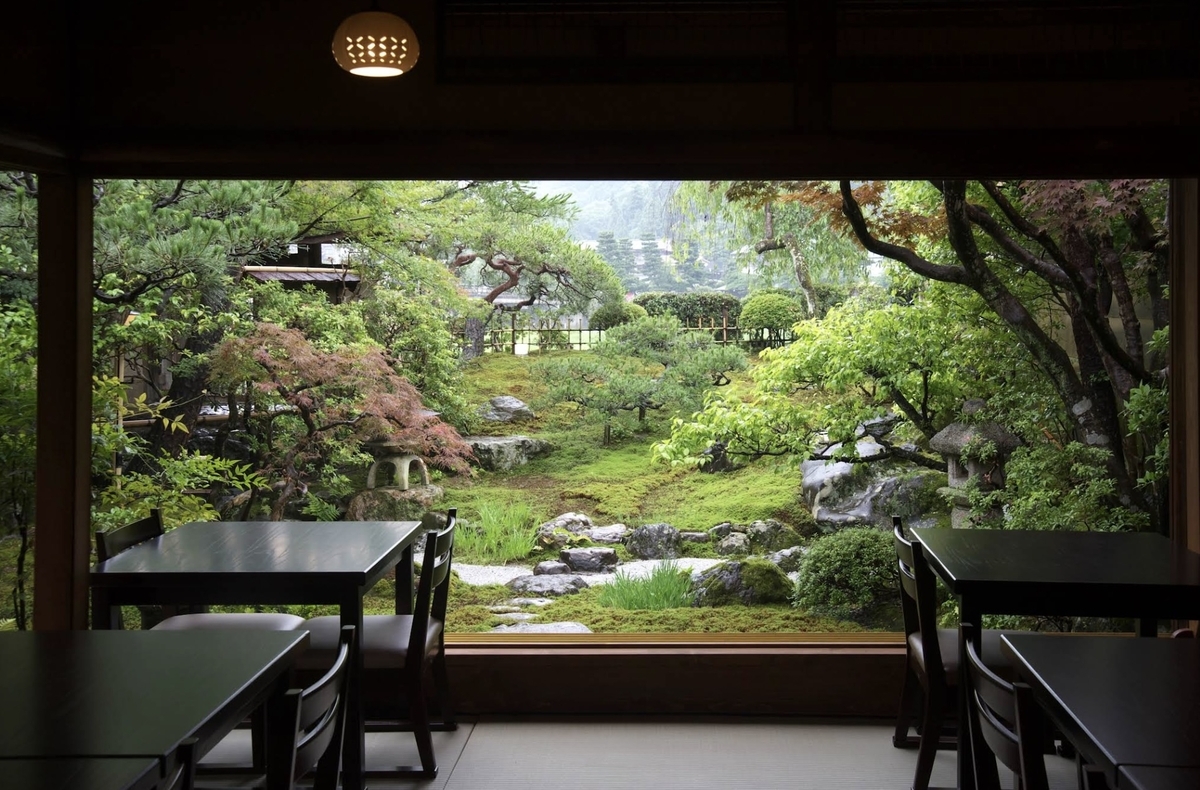 豆腐料理松ヶ枝の座敷席から眺める苔庭と石灯籠の日本庭園
