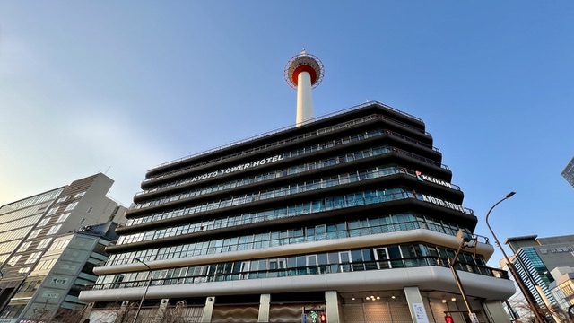 青空を背景にそびえる京都タワーと京都タワーホテルの外観
