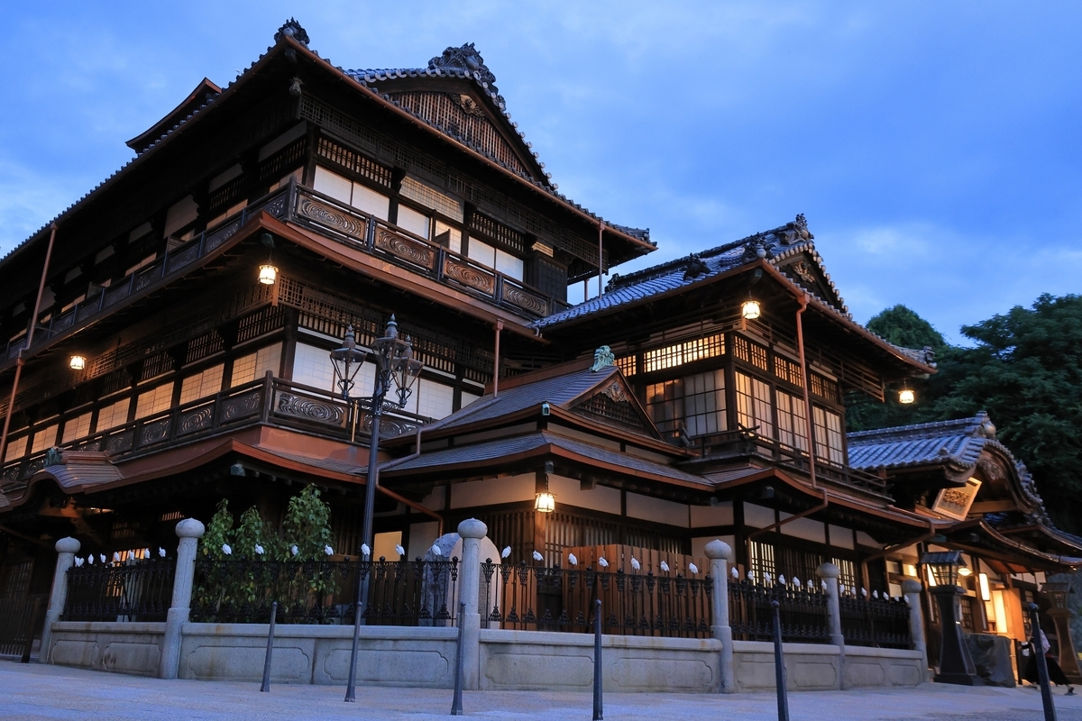 道後温泉本館の外観。明りが灯り伝統建築が柔らかく照らされている