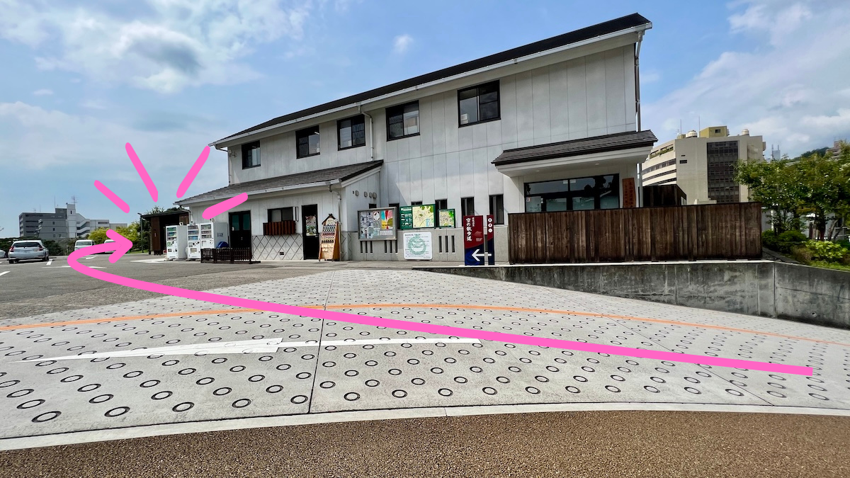 坂道を上り切ったら建物の脇に空の散歩道の入口