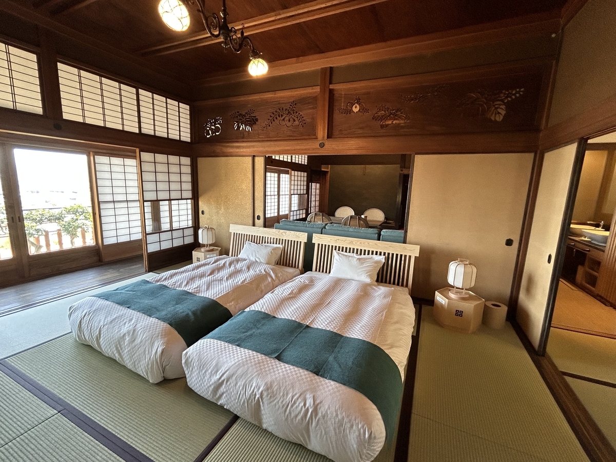 延寿閣別館の室内。畳の間に布団が並ぶ落ち着いた和風空間と障子越しの光