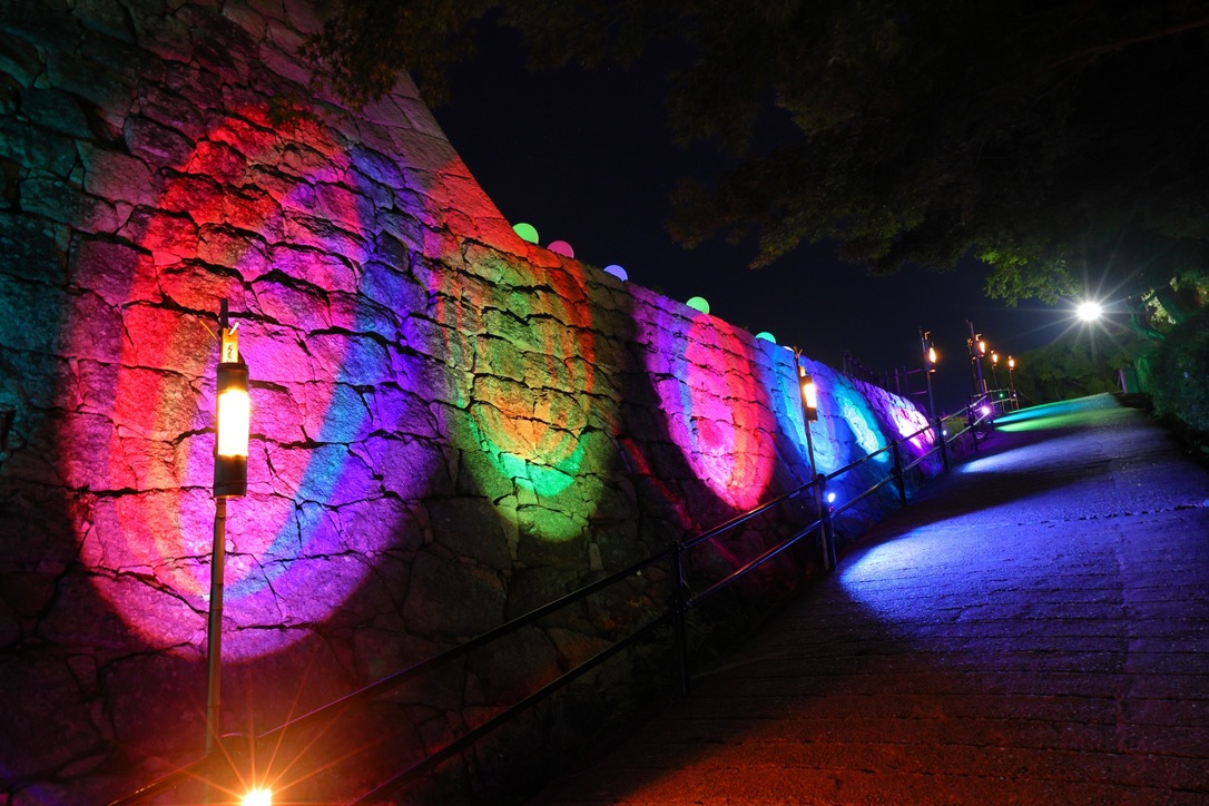 ライトアップされた丸亀城の石垣。色とりどりの光が城の夜を彩る