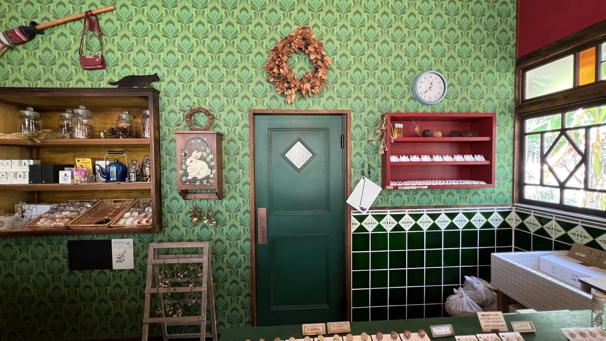 ロケセット店内の全景 カウンターと緑のタイル 赤い扉と棚