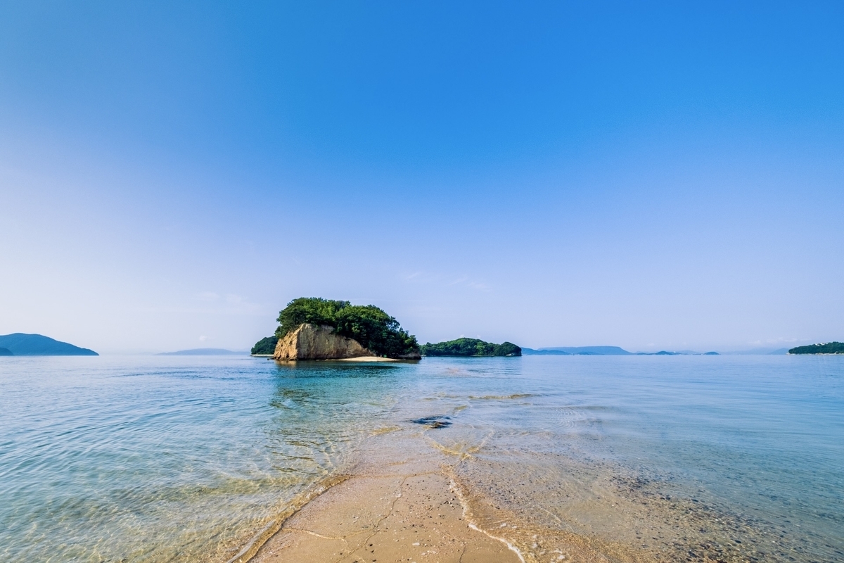 干潮時に現れたエンジェルロードの砂の道と青い海に浮かぶ小島の風景