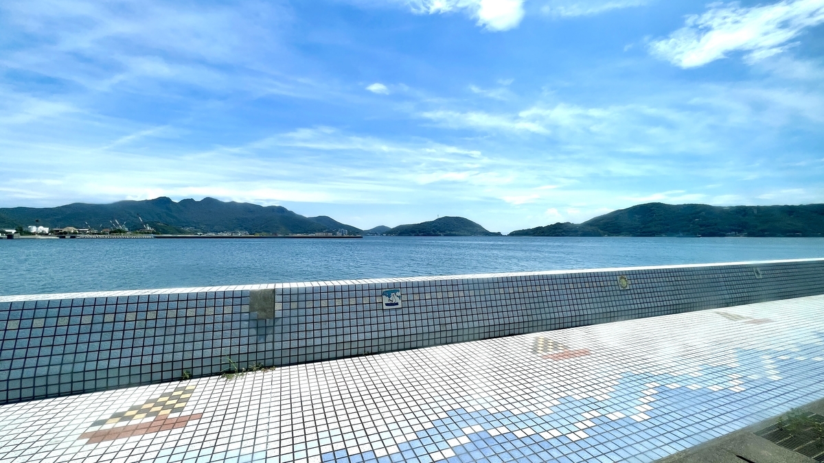 瀬戸内海と青空を背景にしたモザイクタイルの遊歩道と水平線の景色