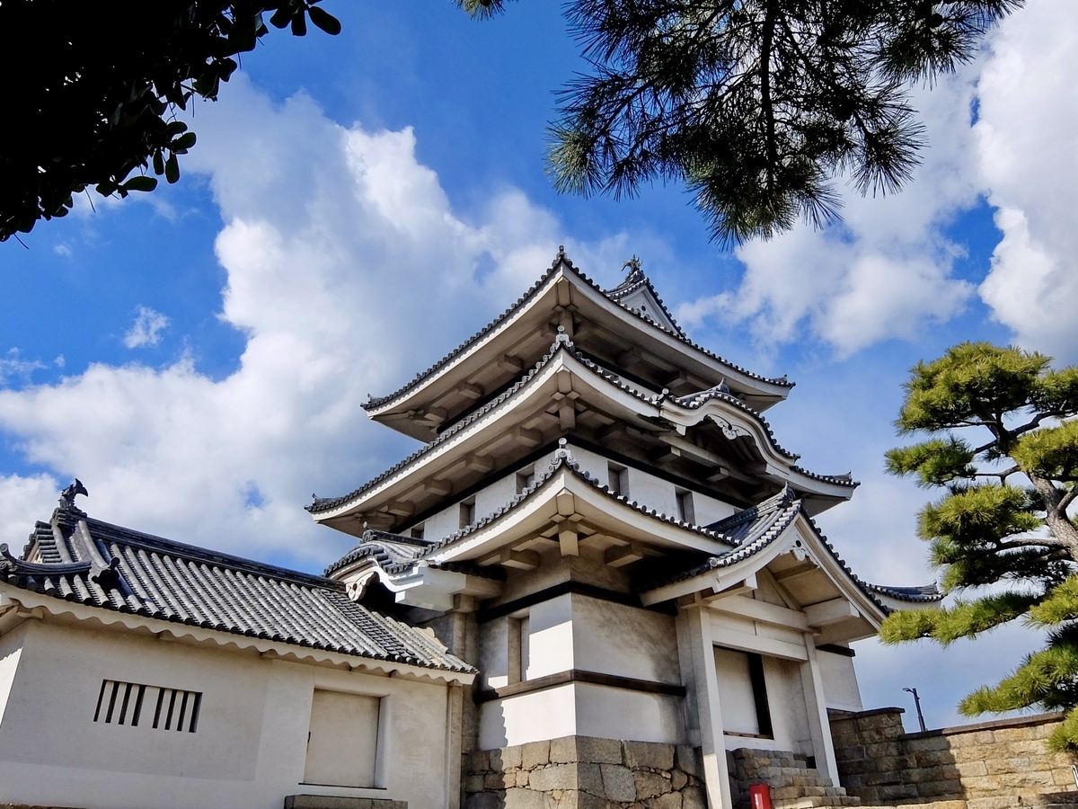 松の木陰にたたずむ月見櫓 白壁と黒瓦が青空に映える高松城の象徴的建築