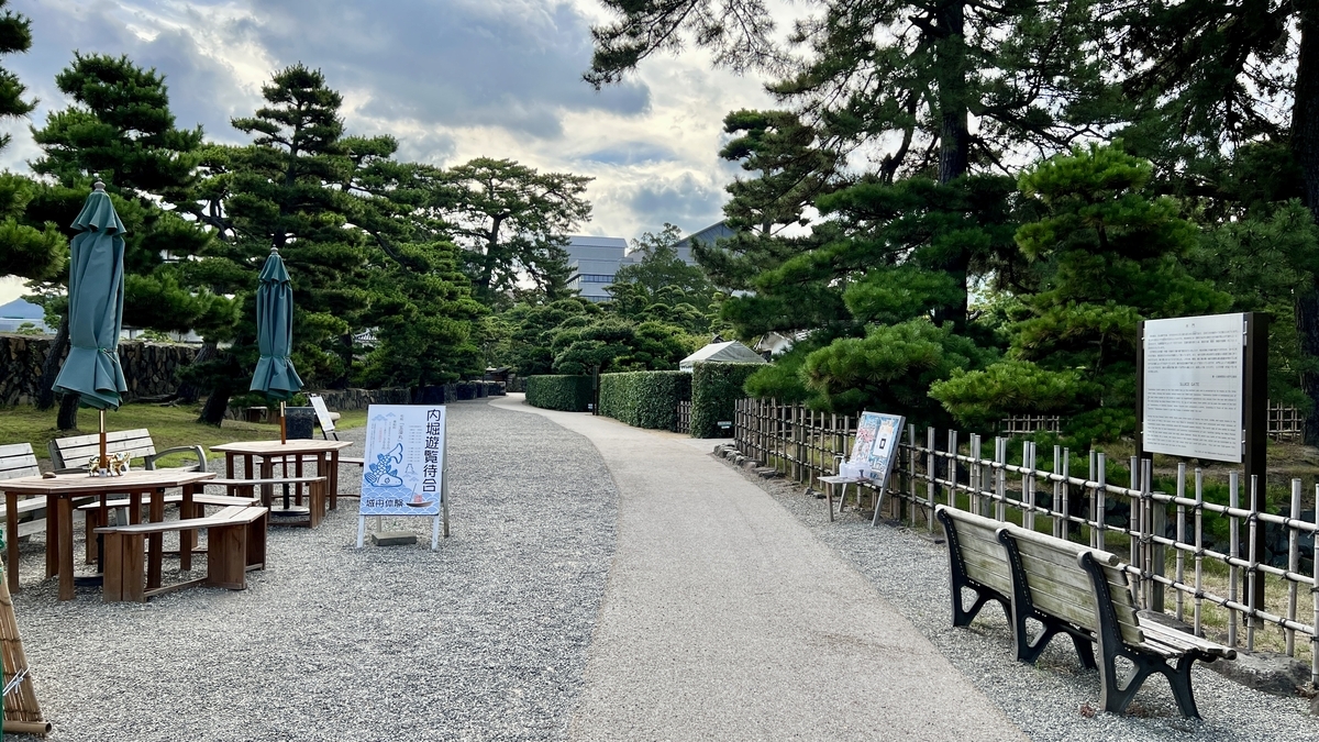 乗船受付所と城舟体験の案内板が並ぶ高松城の堀沿いの遊歩道