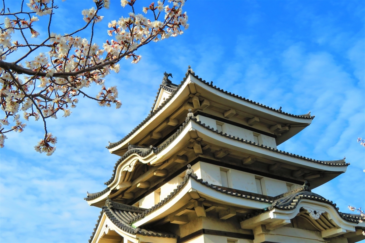 桜の枝越しに見上げる月見櫓と青空 高松城の春を象徴する風景