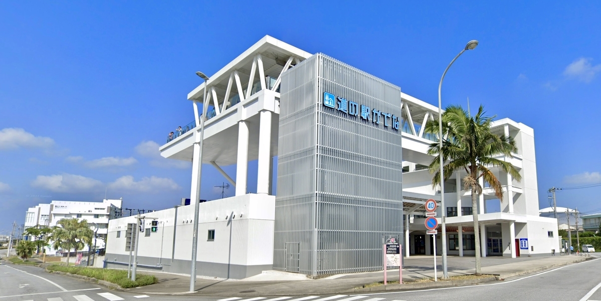青空の下に建つ白い外観の道の駅かでなの正面外観