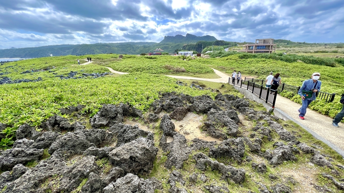 辺戸岬の草原を歩く観光客と遊歩道の景色