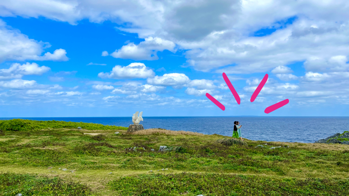 かりゆしの像越しに与論島を望む辺戸岬の風景