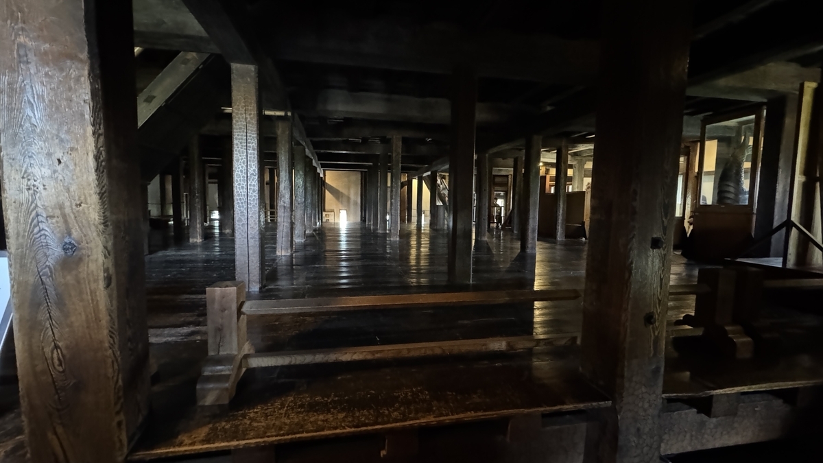 松本城天守一階 規則的に並ぶ木の柱と広い床