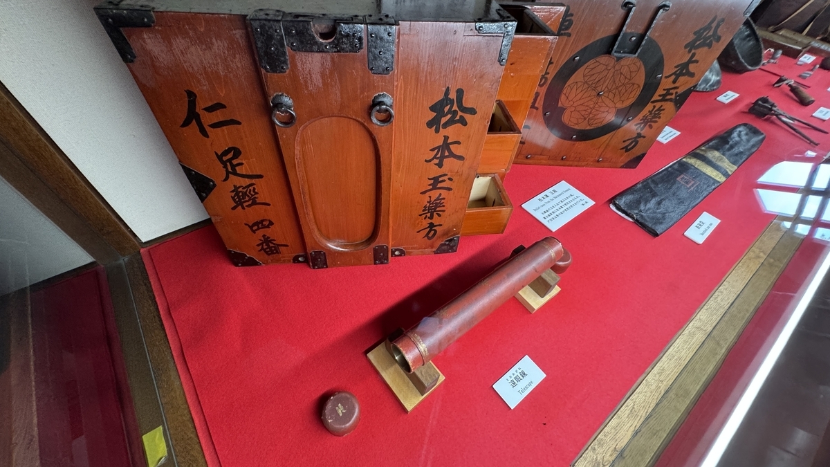 松本城辰巳附櫓 赤い台に並べられた木札と武具の展示