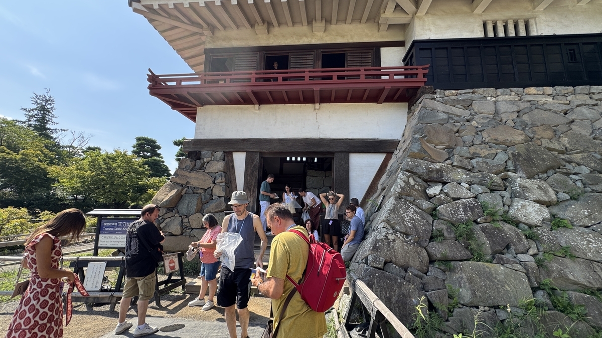 松本城天守出口で靴袋を返却する来館者の様子