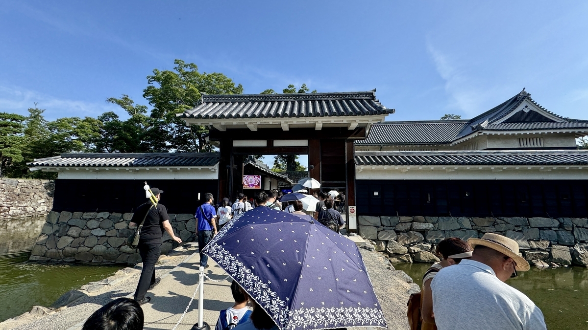 高麗門前で入場待ちの列を作る観光客の様子