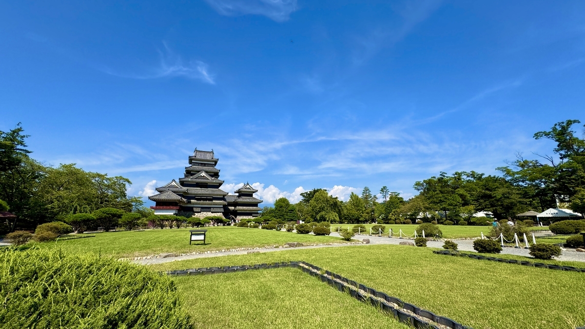 芝生越しに眺める松本城天守と本丸庭園の風景