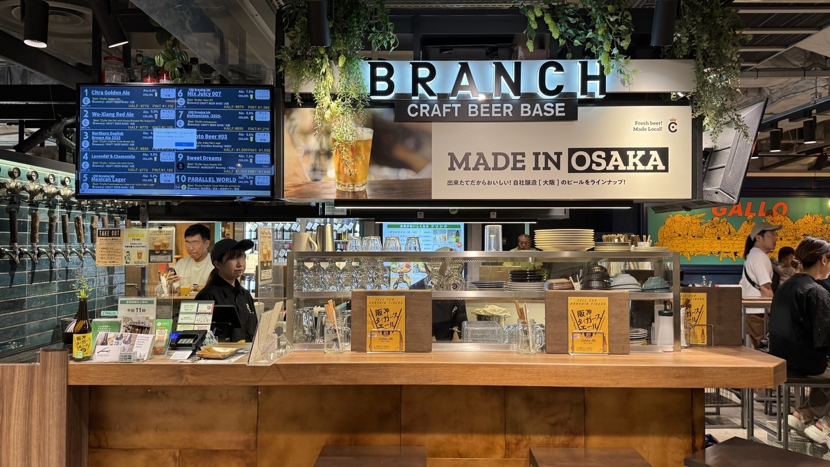 阪神バル横丁内のクラフトビール専門店クラフトビアベースブランチ。カウンター越しにスタッフが接客をしている様子。