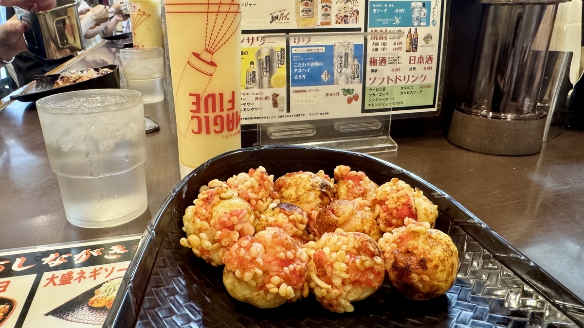 黒い皿に盛られたたこ焼き十八番西中島本店のソースマヨたこ焼き