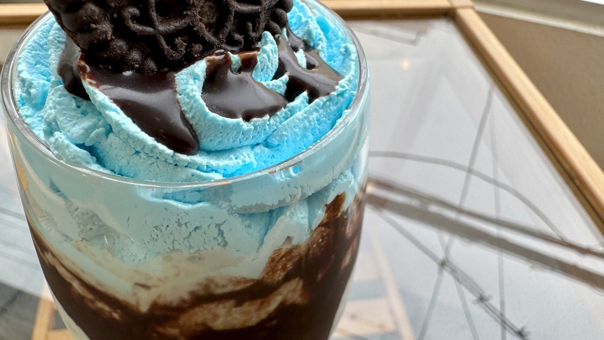 ミント色のホイップとチョコレートソースが美しく重なったシェイクのアップ