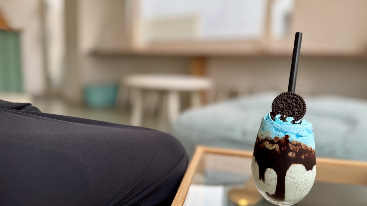 店内の席の上に置かれたチョコミントシェイクと落ち着いた背景