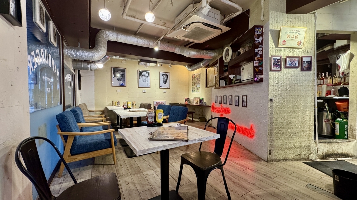 ネオンの赤い光とウッドテーブルが印象的なRICH GARDEN 心斎橋本店の店内