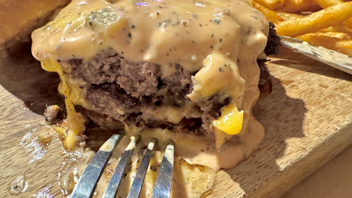パティ二枚とチーズソースが重なったオーセンティックダブルチーズバーガーの断面