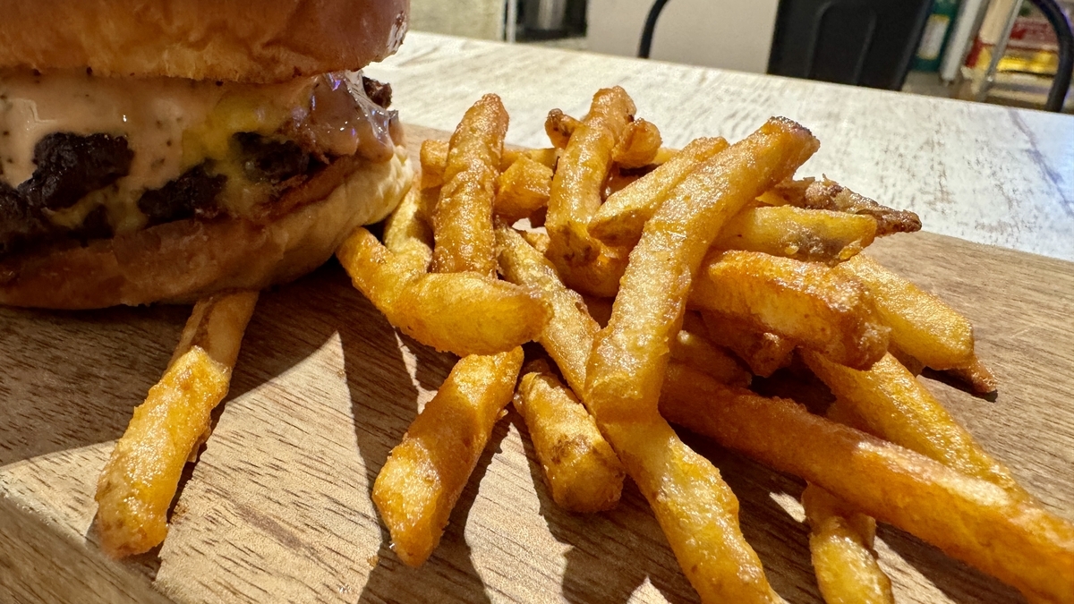 オーセンティックダブルチーズバーガーの横に山盛りのポテトフライが添えられた一皿