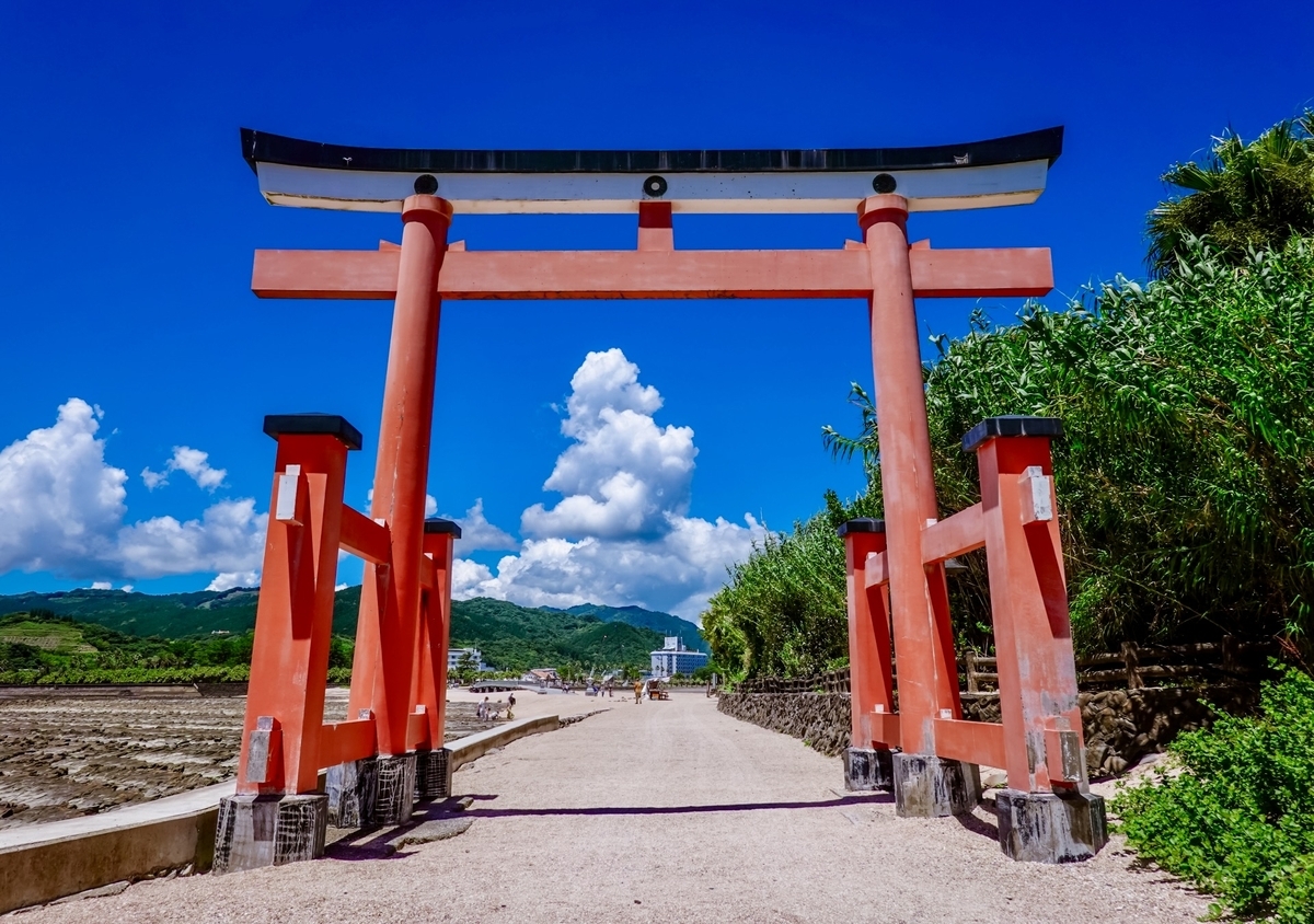 南国の緑と青空を背に立つ青島神社の赤い鳥居