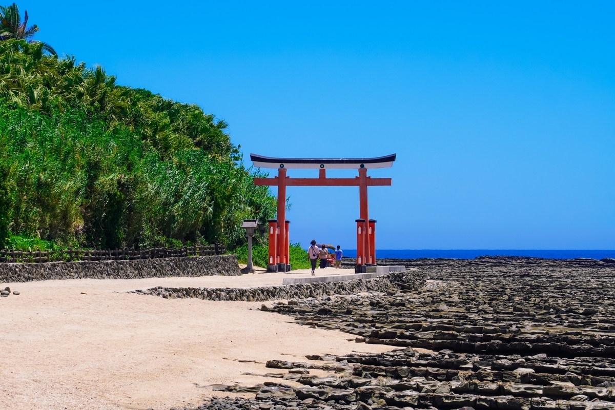 海と白砂の参道に真っ赤な鳥居が映える青島神社の入口の景色