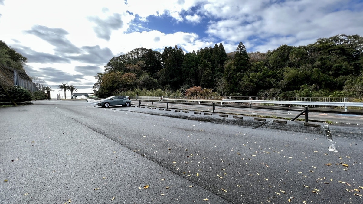 堀切峠にある無料駐車場の広々とした舗装エリアと周囲の緑の景色