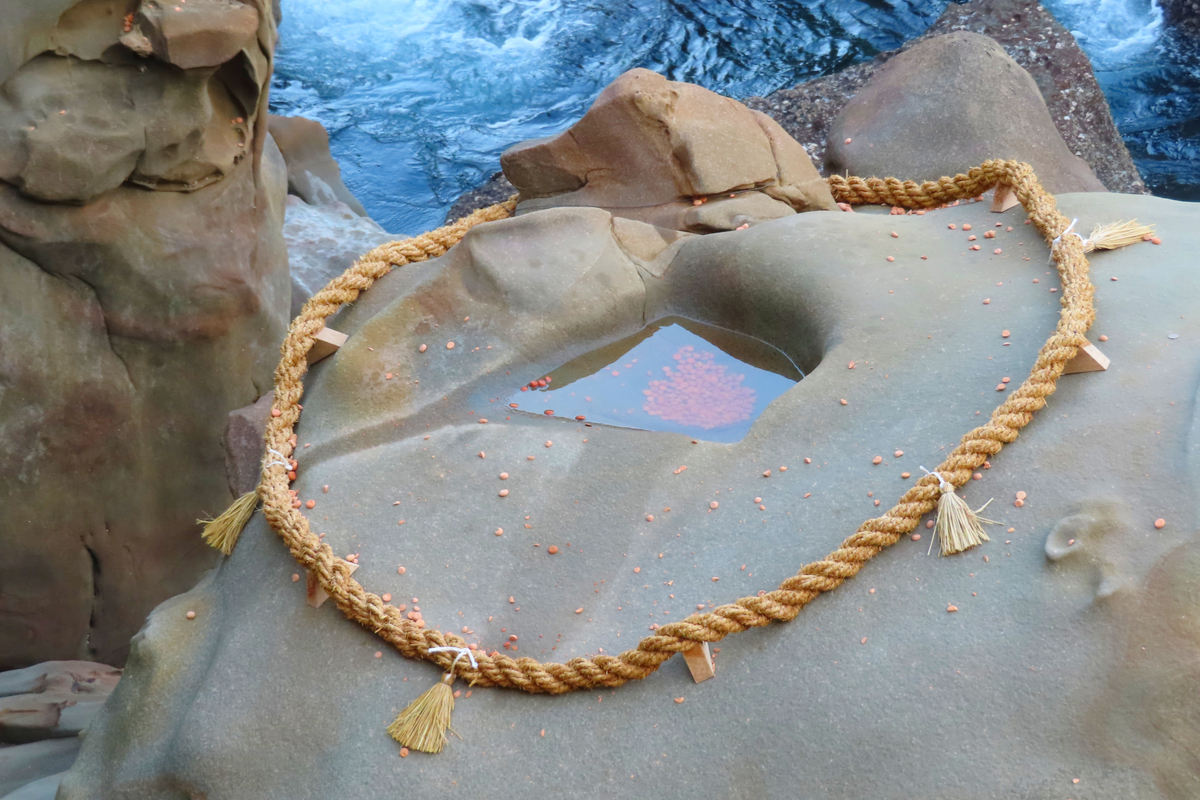 窪みのある霊石亀石と周囲の縄飾りの様子