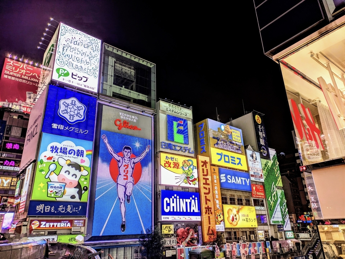 道頓堀グリコ看板前の夜景と人の往来が見られる賑やかな通り