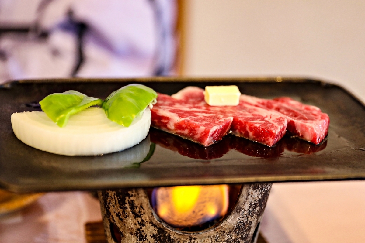 溶岩プレートで焼かれる高千穂牛の赤身肉と付け合わせの野菜