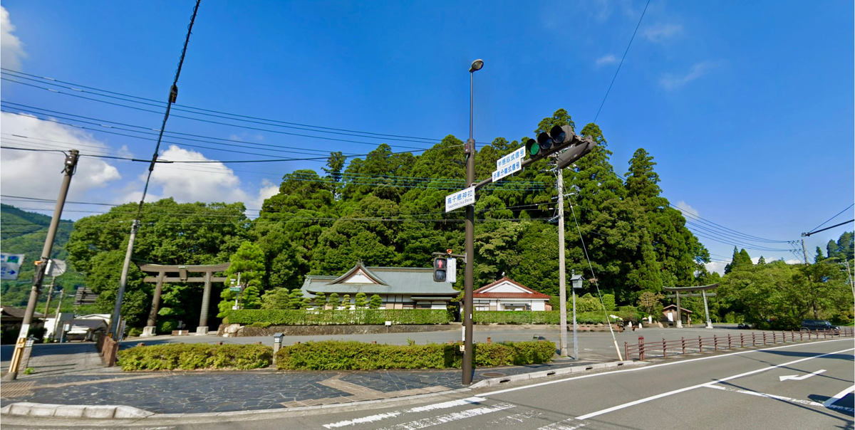 高千穂神社周辺の道路と神社の森が見える交差点付近の風景