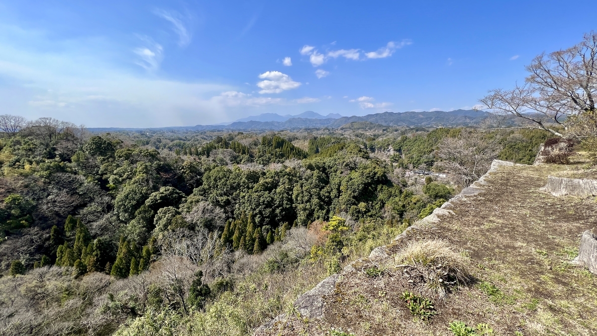 石垣の縁から見渡すくじゅう連山と深い谷の大パノラマ