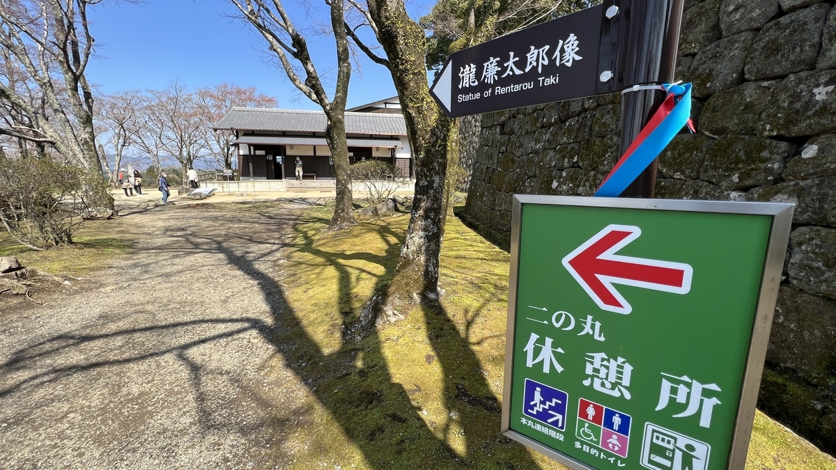 二の丸休憩所の案内看板と広場の建物