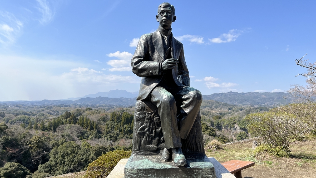瀧廉太郎像が山並みを背に座る岡城の展望