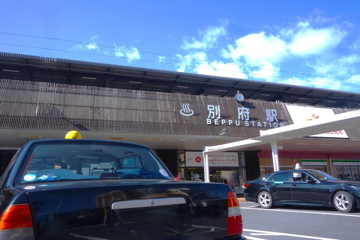 別府駅の駅舎前に停車するタクシーと駅の看板