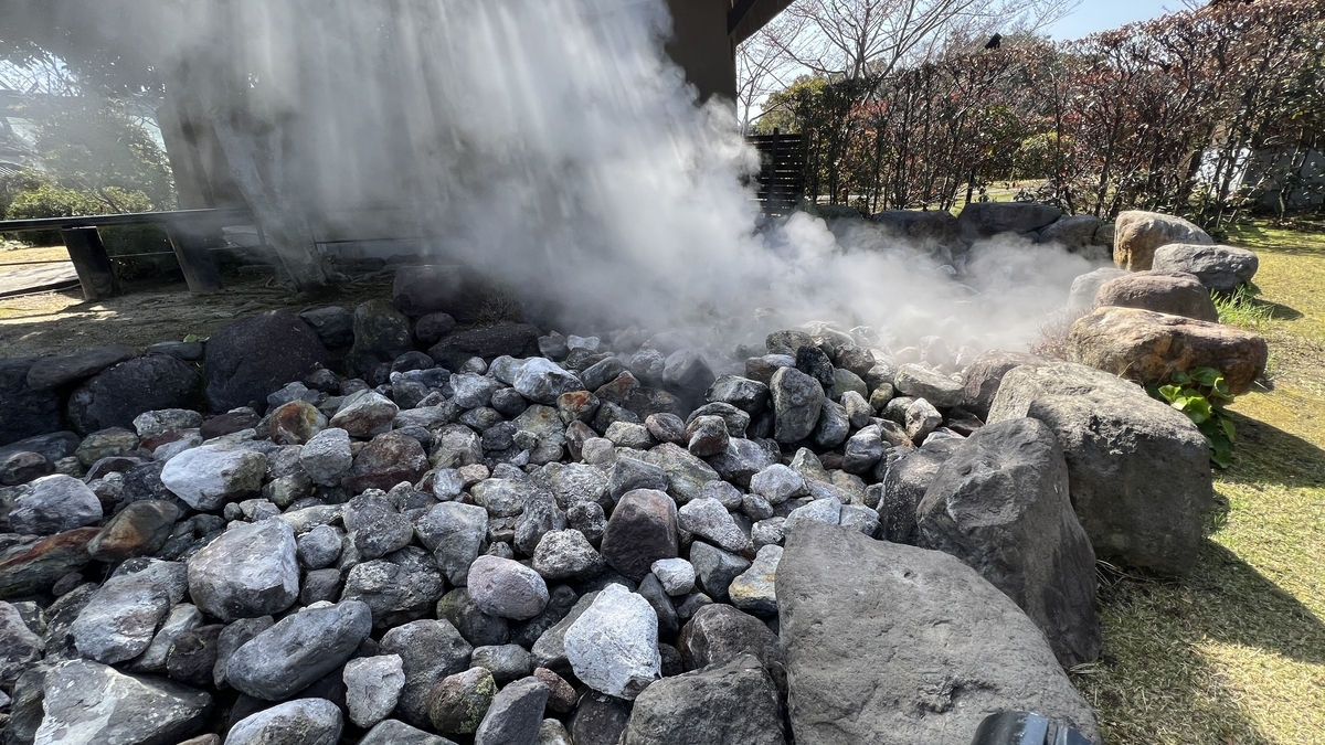 鬼石坊主地獄の間欠泉で白い蒸気が噴き上がり石が積まれた周囲の様子
