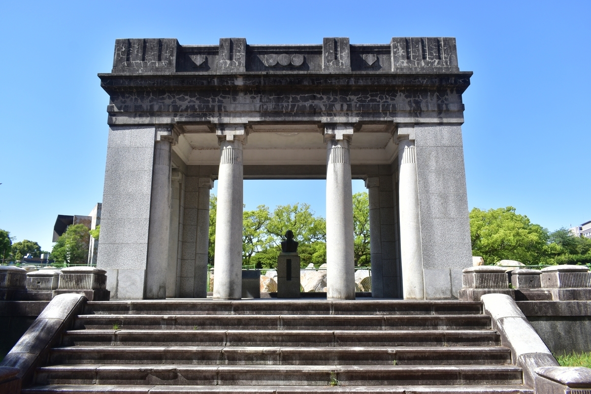 高橋公園の石造りの記念門と中央の石段 四本の柱の奥に銅像が見える正面景観