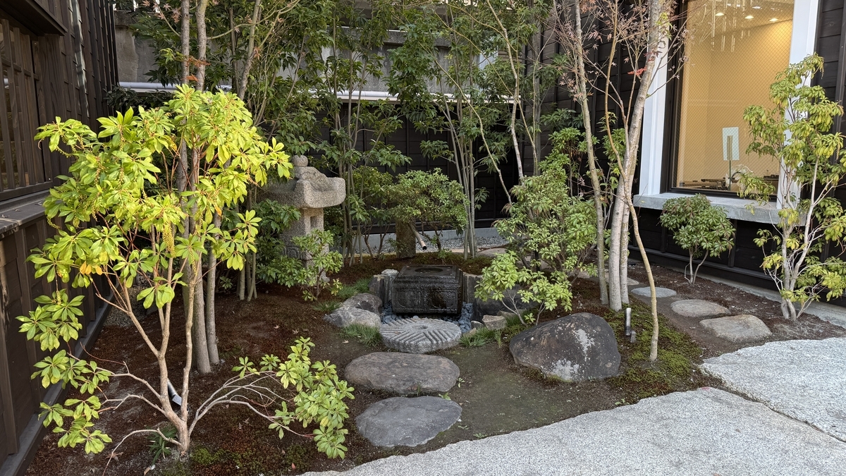 町屋の間に設けられた小さな日本庭園 石灯籠と飛び石が並ぶ苔の庭
