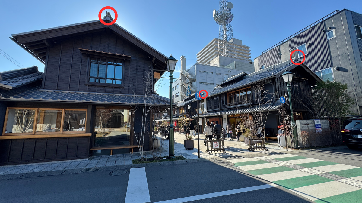 屋根の鬼瓦が丸印で示された町屋の通り 交差点と歩行者が行き交う小江戸甲府花小路の入口