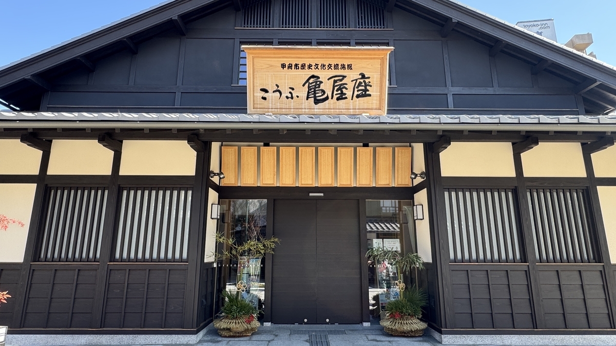 歴史文化交流施設こうふ亀屋座の正面 木格子と大きな木製看板が掲げられた外観