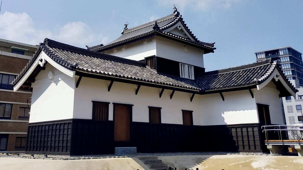 白壁と黒瓦の屋根が重なる復元された福岡城潮見櫓の外観と背後の青空
