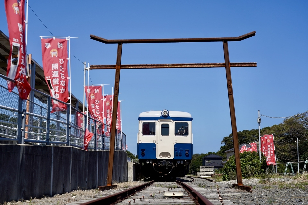 錆びたレール鳥居の奥に青と白の気動車キハが停車するひたちなか開運鐵道神社の構内