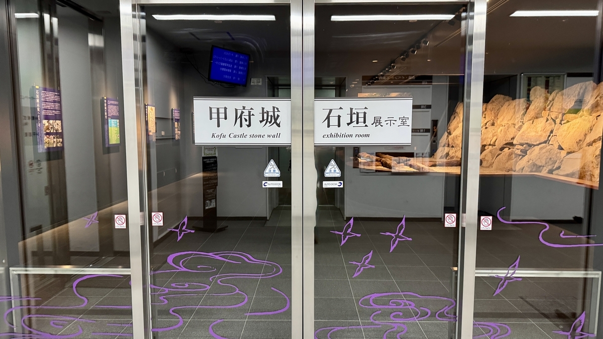 甲府城石垣展示室の入口ガラス扉と館名サイン
