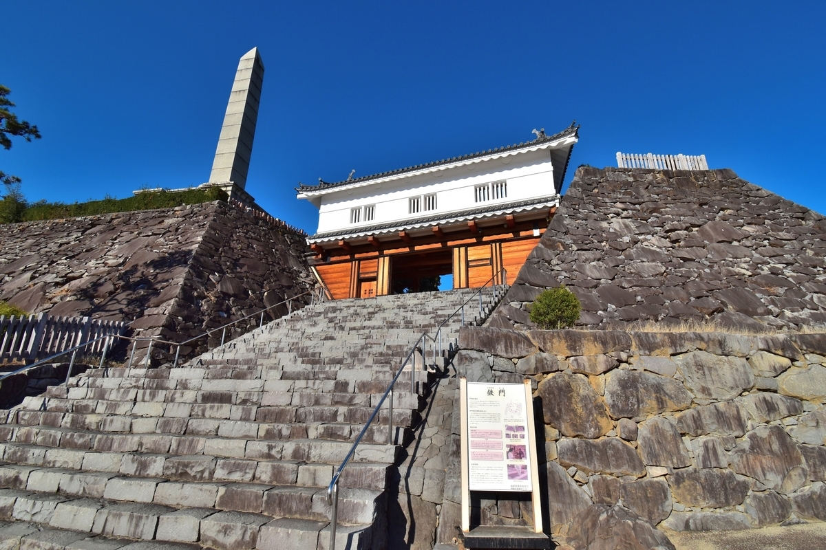 石段の正面に立つ鉄門と左右の石垣