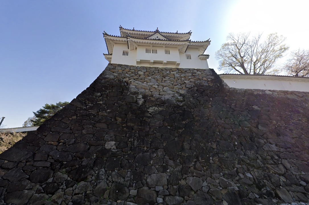 天守台の石垣を下から見上げた白壁の櫓と瓦屋根