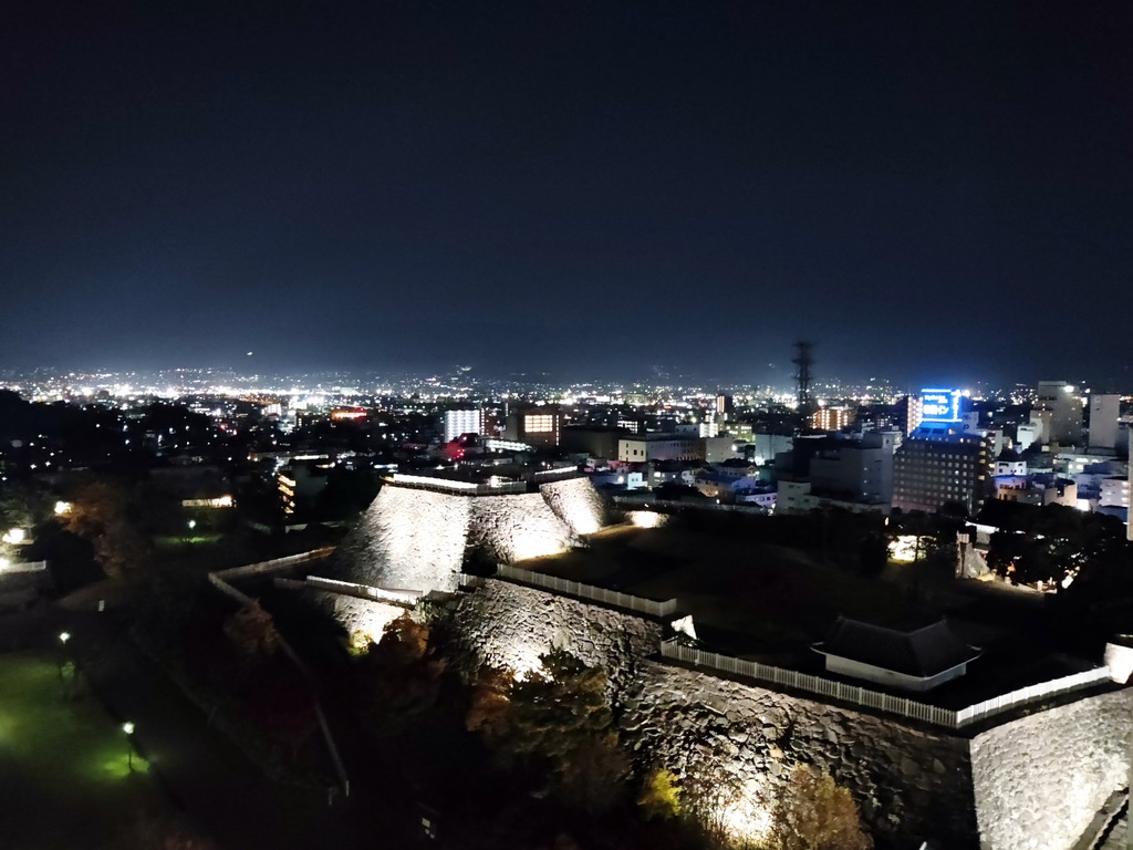 ライトアップされた石垣と甲府市街の夜景のパノラマ