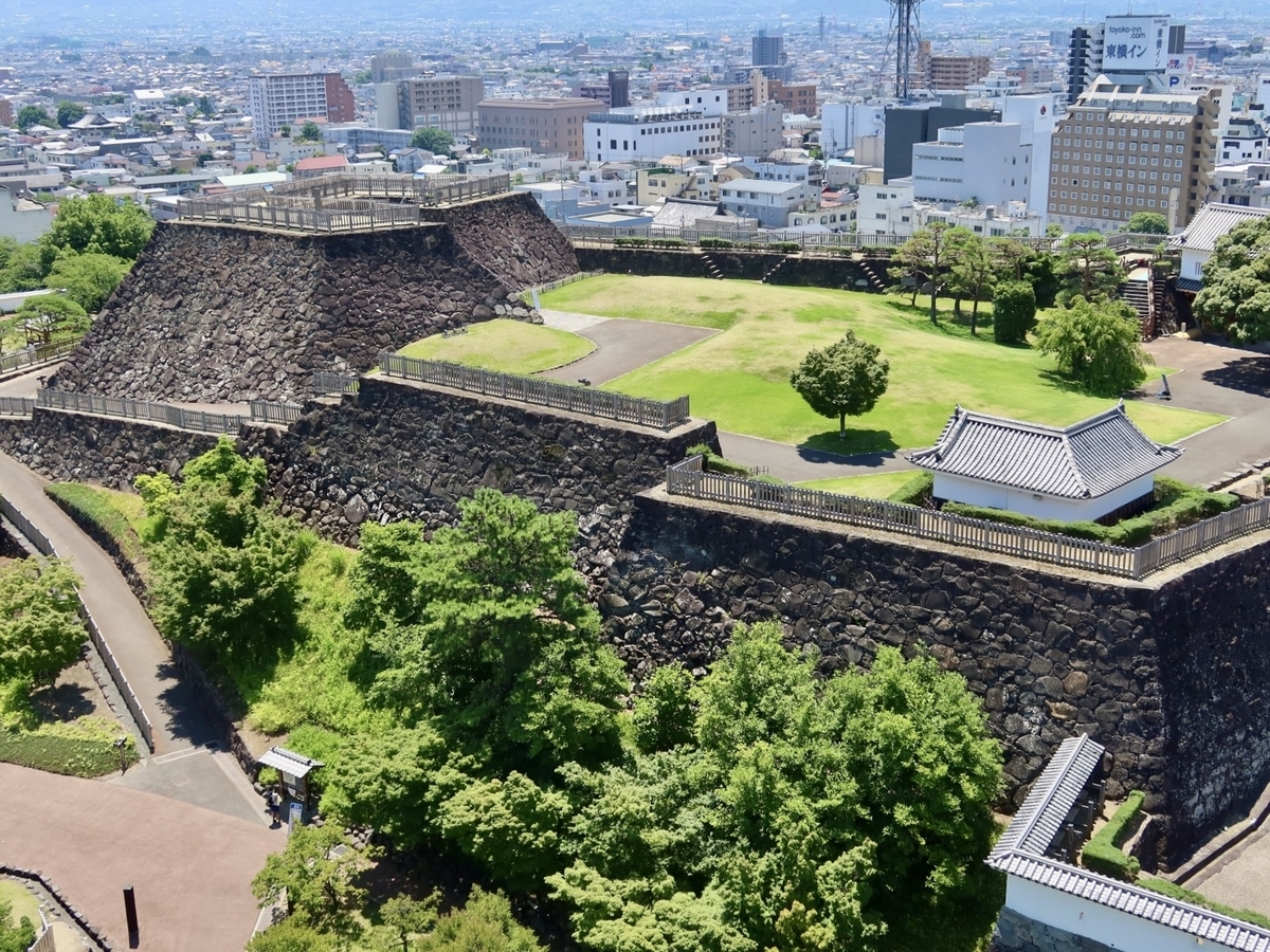甲府城の高い石垣と芝生の曲輪を俯瞰した景色